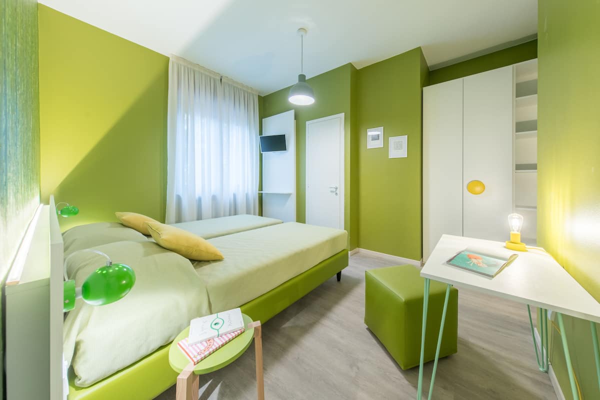 Une chambre comprenant un lit, un bureau, une chaise et une armoire.