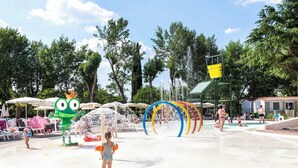 A water park with a large water fountain, colorful play structures, and umbrellas. - Hotel La Diga - Altomincio Family Park (Valeggio sul Mincio)