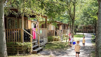 A row of wooden cabins with wooden decks and stairs leading to the entrance.