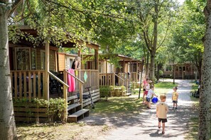 A row of wooden cabins with wooden decks and stairs leading to the entrance. - Hotel La Diga - Altomincio Family Park (Valeggio sul Mincio)