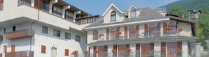 Un immeuble à plusieurs étages doté de balcons, de grandes fenêtres et de jardinières.