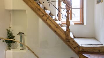 A wooden staircase with a wrought iron balustrade leading to a landing.