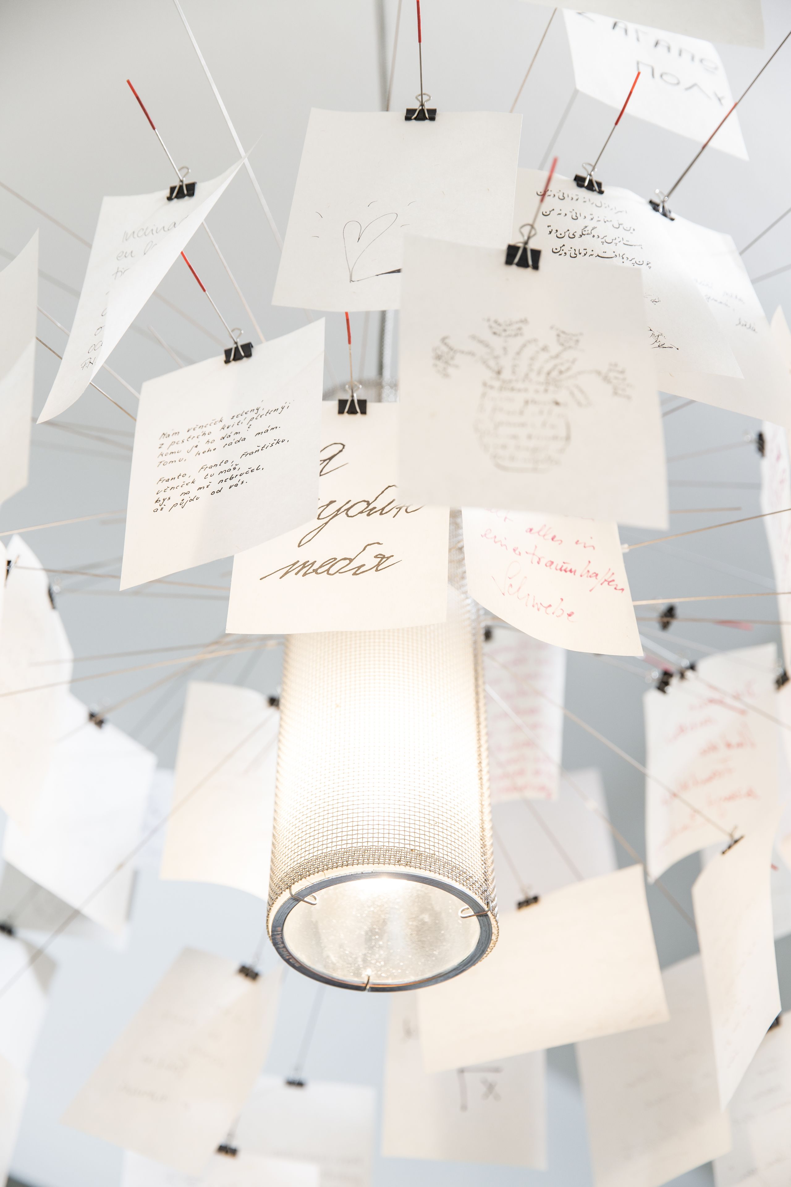 A chandelier with multiple notes attached to it.