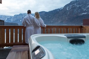 A couple on a balcony overlooking a mountainous landscape with a hot tub in the foreground. - Hallstatt Hideaway - Adults only (Hallstatt)