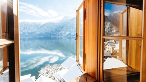 Una habitación con un ventanal que ofrece vistas a un lago y montañas.