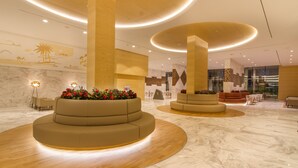 A modern lobby with circular seating areas, a marble floor, and a large wall mural. - ESTIMAR Calpe Suitopia (Calpe)