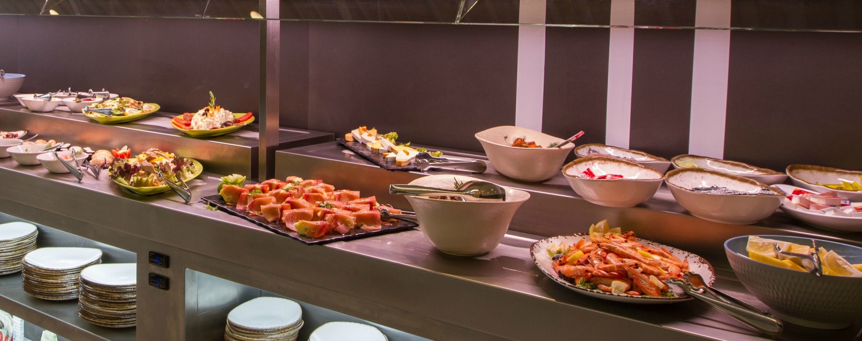 A buffet with various dishes including seafood, salads, and desserts.