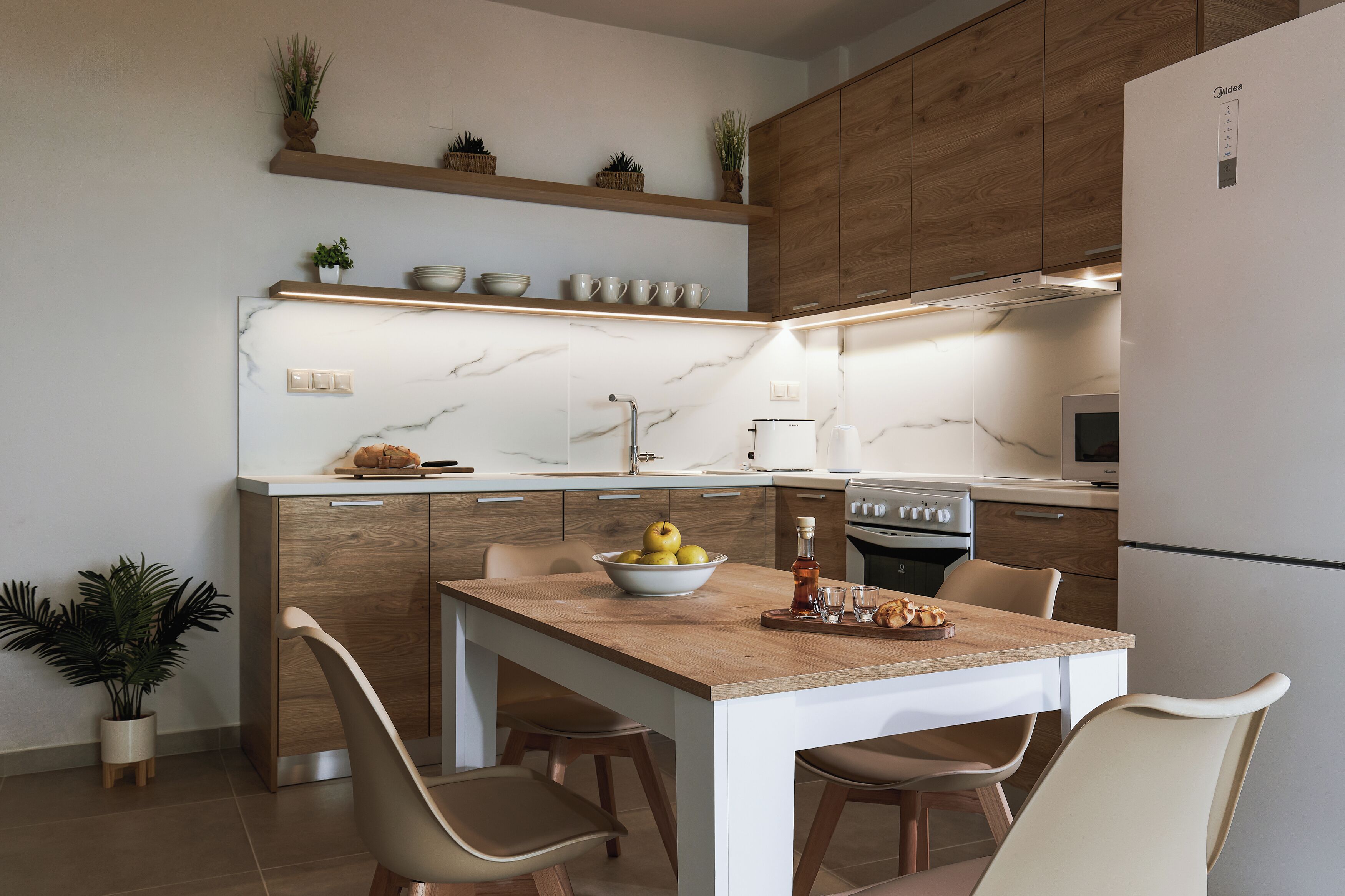 A modern kitchen with wooden cabinets, a marble countertop, and a central island with seating.