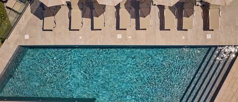 Een seizoensgebonden buitenzwembad, parasols voor strand/zwembad