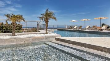 Piscina a l'aire lliure de temporada, para-sols i gandules