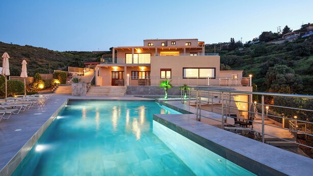 A modern hotel with a swimming pool, outdoor seating, and a hillside view. - OZEA - Elevated Living (Malevizi)