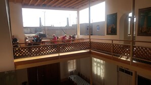 A balcony with a wooden railing overlooking a courtyard. - Islambek Hotel & Travel (Khiva)