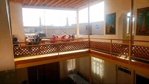 Habitación con techos altos y un balcón con vistas a un patio.