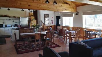 A spacious kitchen with wooden cabinets, a dining area with a table and chairs, and a living room with a sofa.