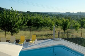 Una piscina al aire libre, sillones reclinables de piscina