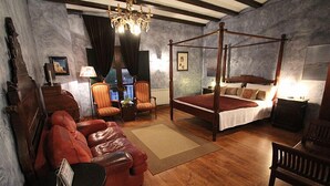 A bedroom with a four-poster bed, a leather sofa, a small table, and a chair. - La Fornal dels Ferrers (Terrades)