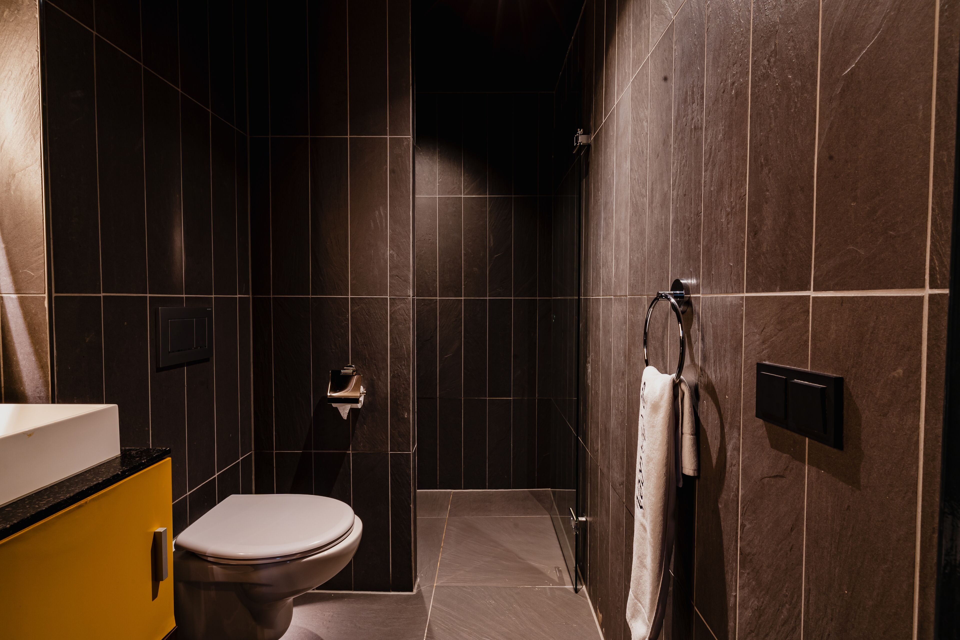 Een moderne badkamer met toilet, wastafel en douche.