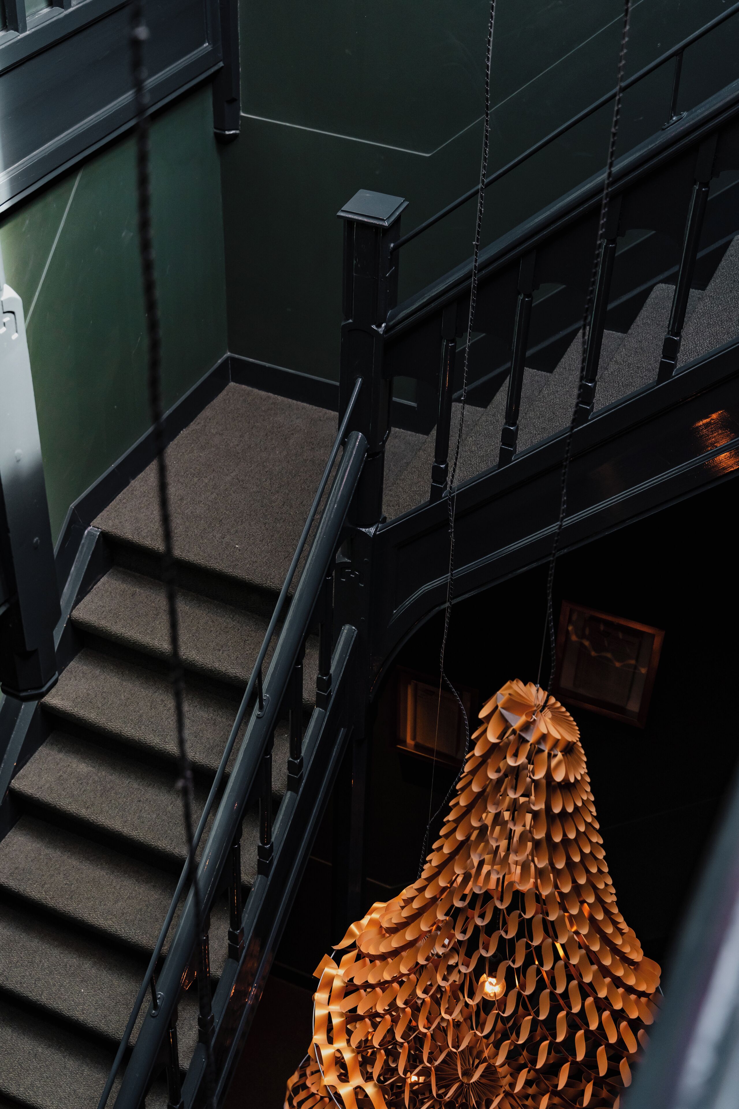 Eine Treppe mit einer einzigartigen, geometrischen Leuchte, die von der Decke hängt.