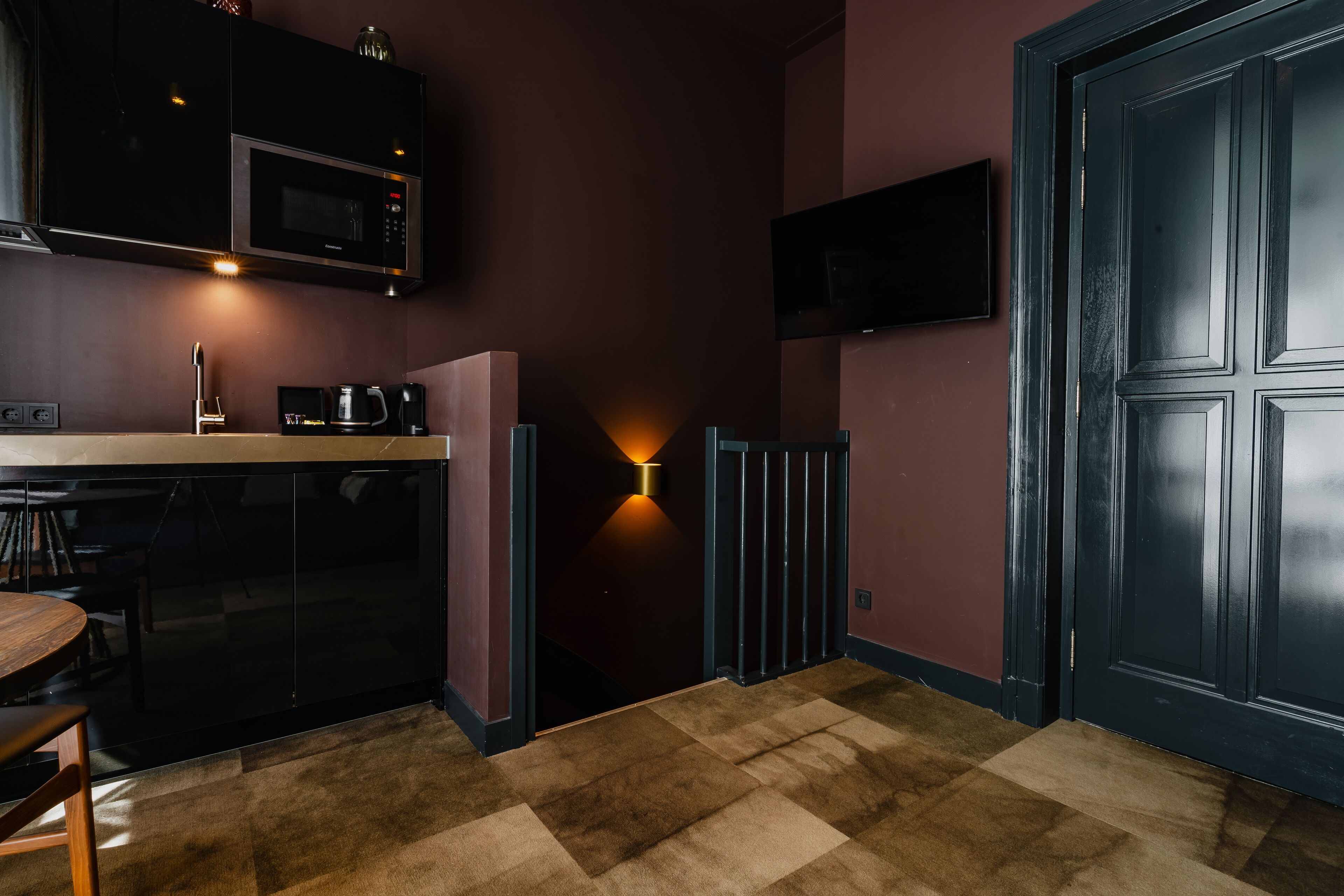A modern kitchen with a microwave, coffee maker, and a dining area with a table and chairs.