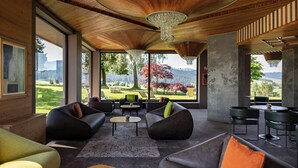 Una habitación amplia con ventanas grandes, techo de madera y muebles modernos.