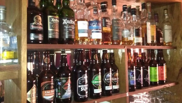 Shelves stocked with various bottles of alcohol, including whiskey, wine, and spirits. - Strathy Inn (Thurso)