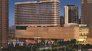 Un hotel modern amb un prominent rètol de 'Hyatt Place', envoltat d'edificis alts i un entorn urbà ben il·luminat.