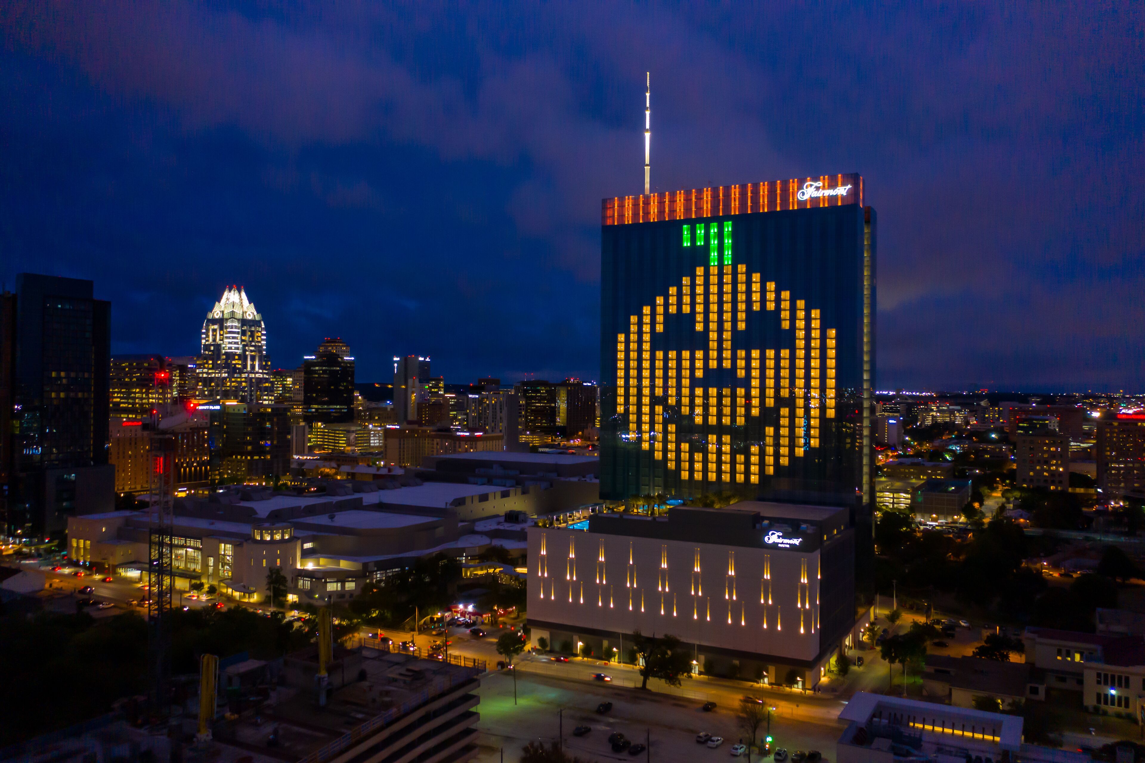 A cityscape at night with a prominent building featuring a large, illuminated skull design on its facade.