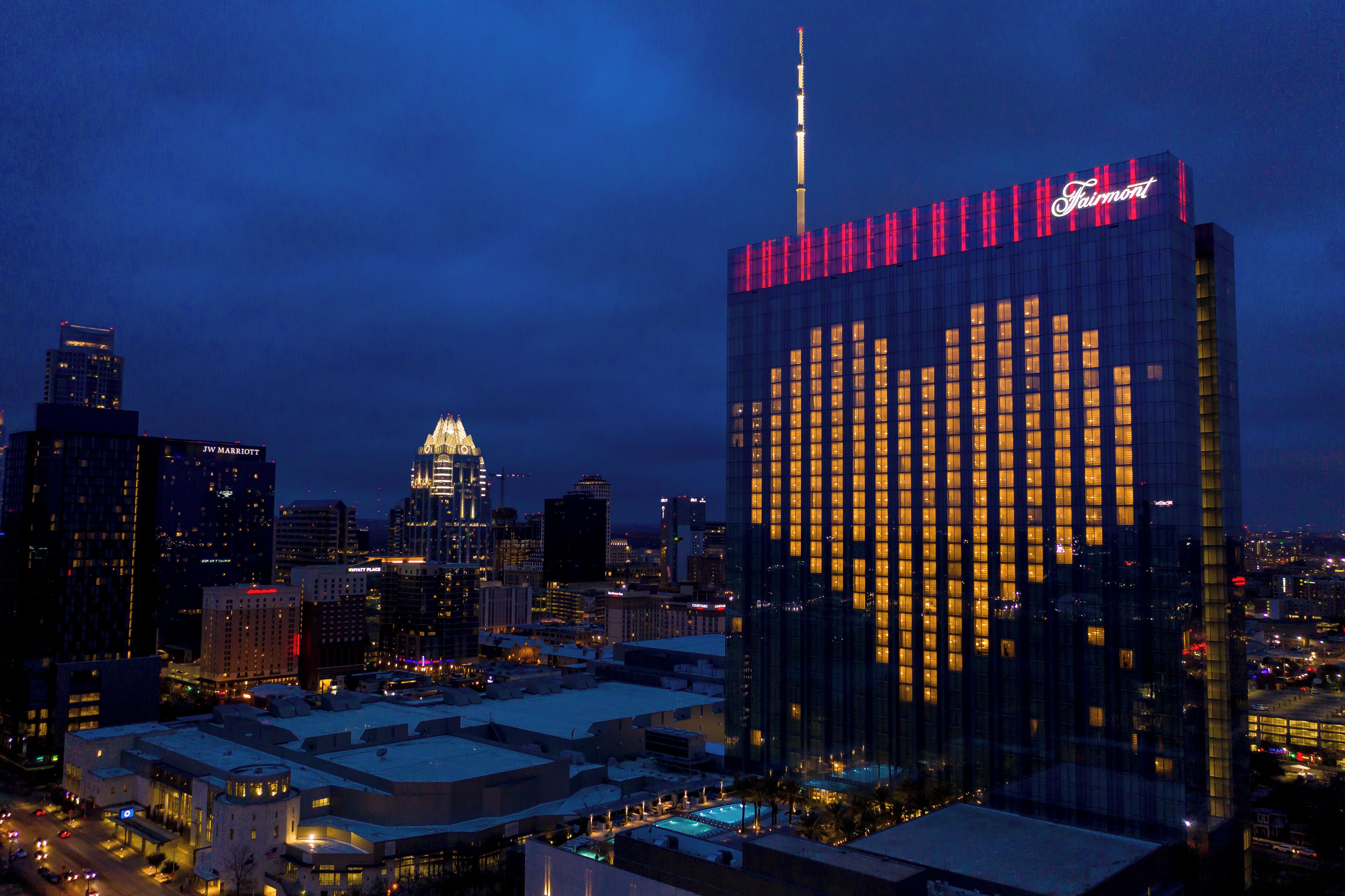Un paisaje urbano nocturno con un edificio destacado que tiene un escaparate con forma de corazón.