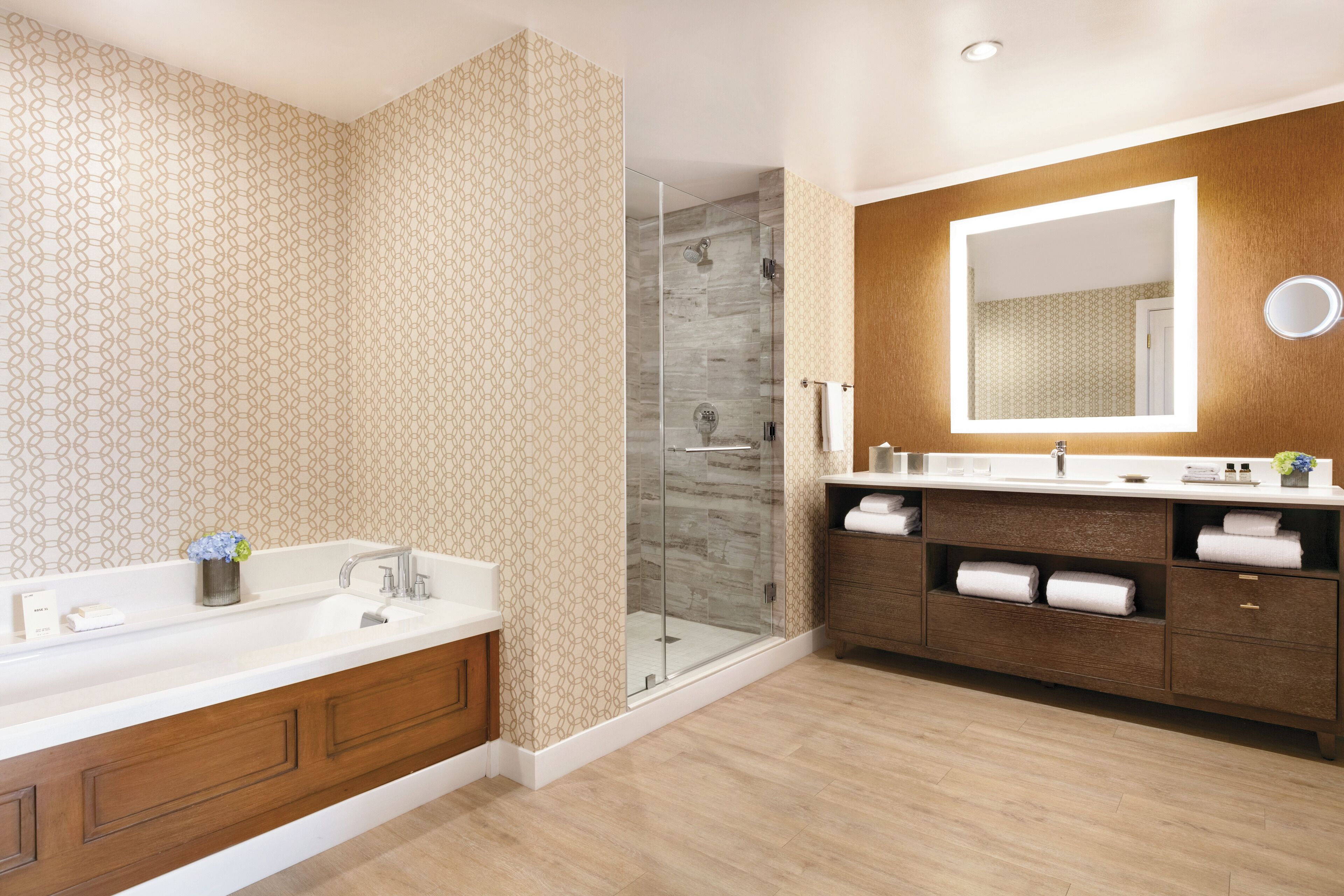 Un baño moderno con lavamanos doble, cabina de ducha de vidrio y un espejo grande.