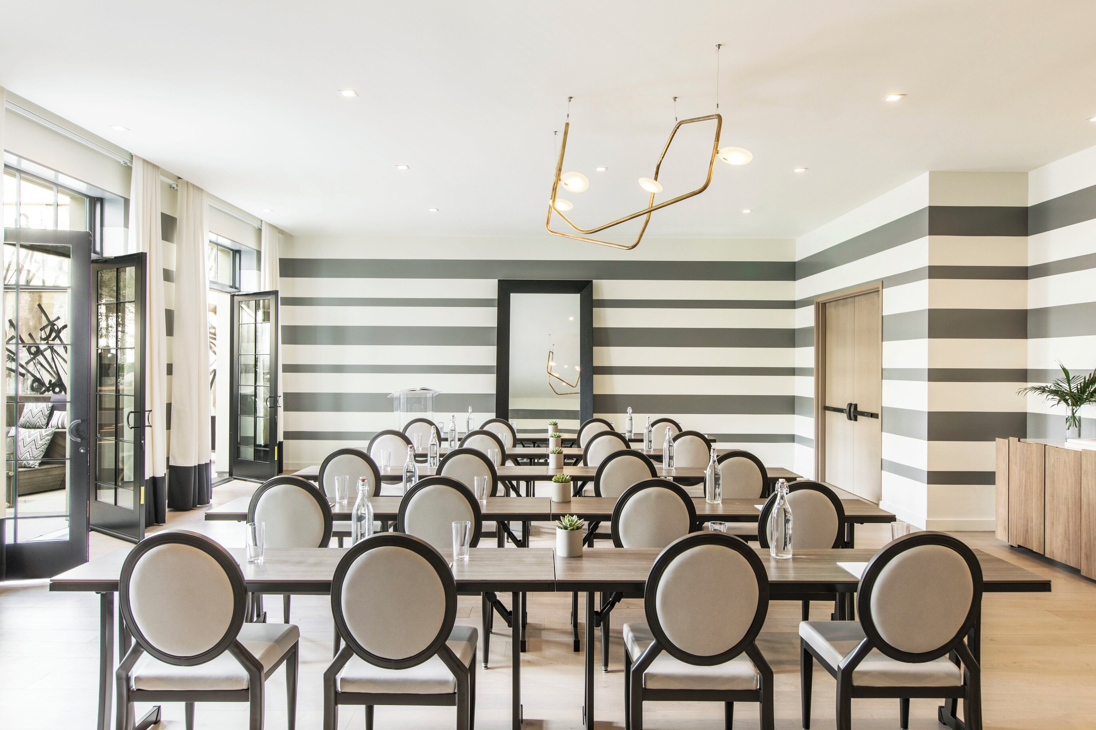 A modern dining area with striped walls, round tables, and chairs.