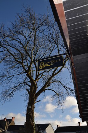 A sign for The Lawrence Hotel mounted on a tree.