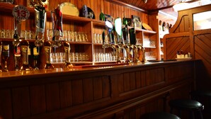 A bar area with wooden shelves holding various bottles and glasses. - The Lawrence (Athboy)
