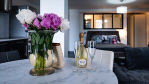 A marble table with a vase of flowers, a bottle of Ruinart champagne, and two glasses. - Hotel Eden Cassis (Cassis)