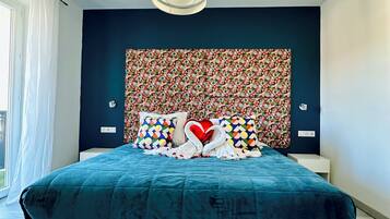 Un dormitorio moderno con una cama grande, un cabecero decorativo y vistas al exterior.