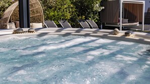A hot tub with bubbles, surrounded by lounge chairs and a wooden structure. - Hotel Eden Cassis (Cassis)