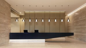 A reception desk with a modern design, featuring a black counter and multiple pendant lights. - Hyatt Place Melbourne, Essendon Fields (Essendon Fields)