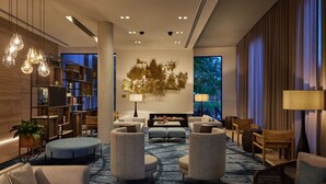 A modern hotel lobby with a fireplace, seating area, and bookshelves. - Hyatt Place Melbourne, Essendon Fields (Essendon Fields)