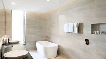 A modern bathroom with a freestanding bathtub, a vanity with a sink, and a glass shower enclosure.