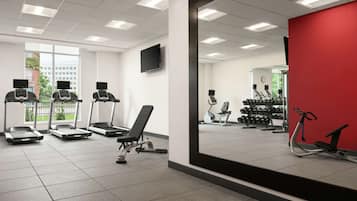 A gym with treadmills, a bench, and dumbbells.