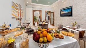 A breakfast buffet with a variety of fruits, pastries, and bread. - Ayres Del Mar (San Vito Lo Capo)