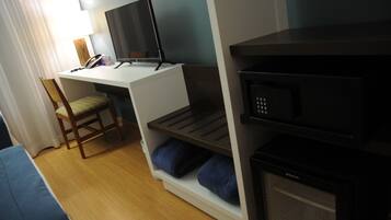 A compact room with a desk, chair, and a microwave.
