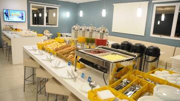 A buffet setup with various food items and utensils.
