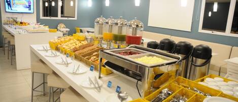 Una mesa de buffet con diferentes alimentos y utensilios.