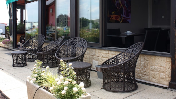 Outdoor wicker chairs and tables in front of a building with a sign reading "Hotel du Relais." - Contact Hôtel du Relais Thouars (Louzy)