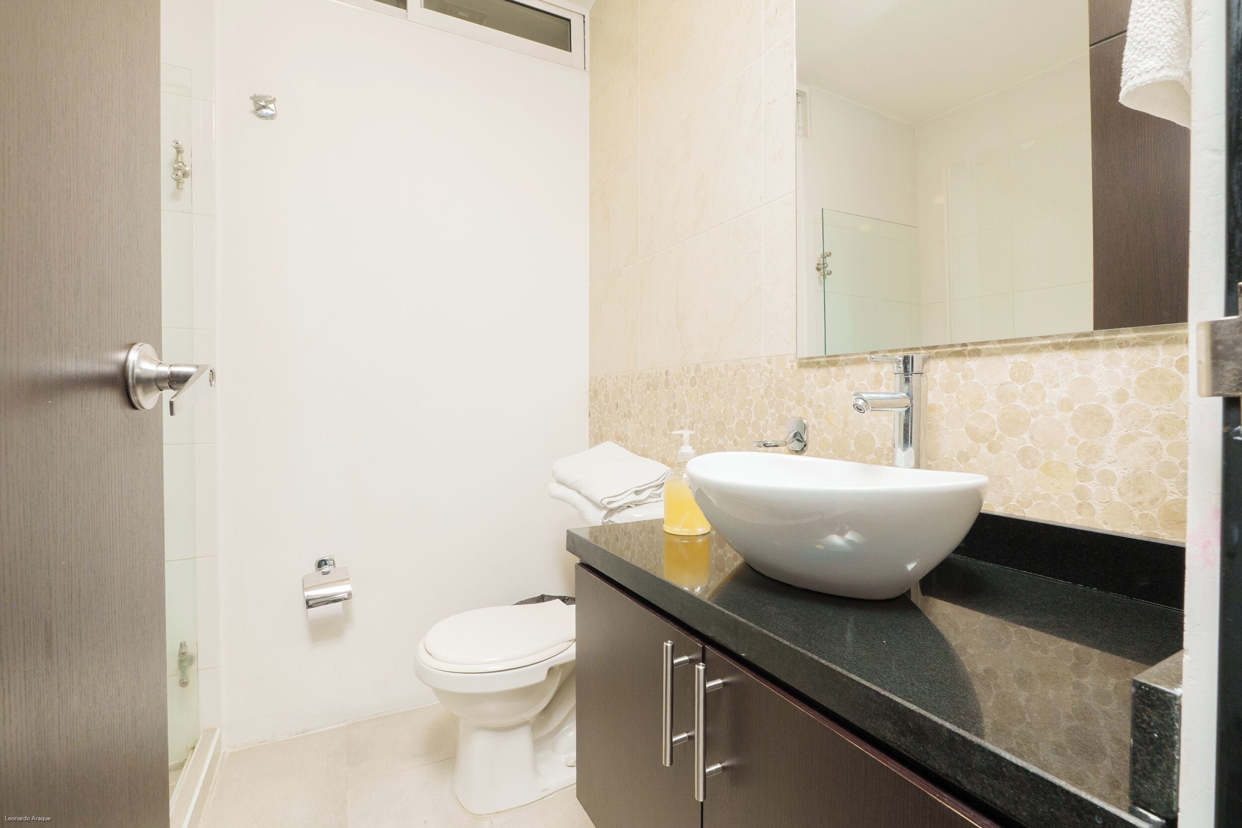 Een badkamer met een toilet, een wastafel en een spiegel.