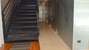 Escadaria que leva a um espaço interior moderno com parede de vidro e piso lustroso.