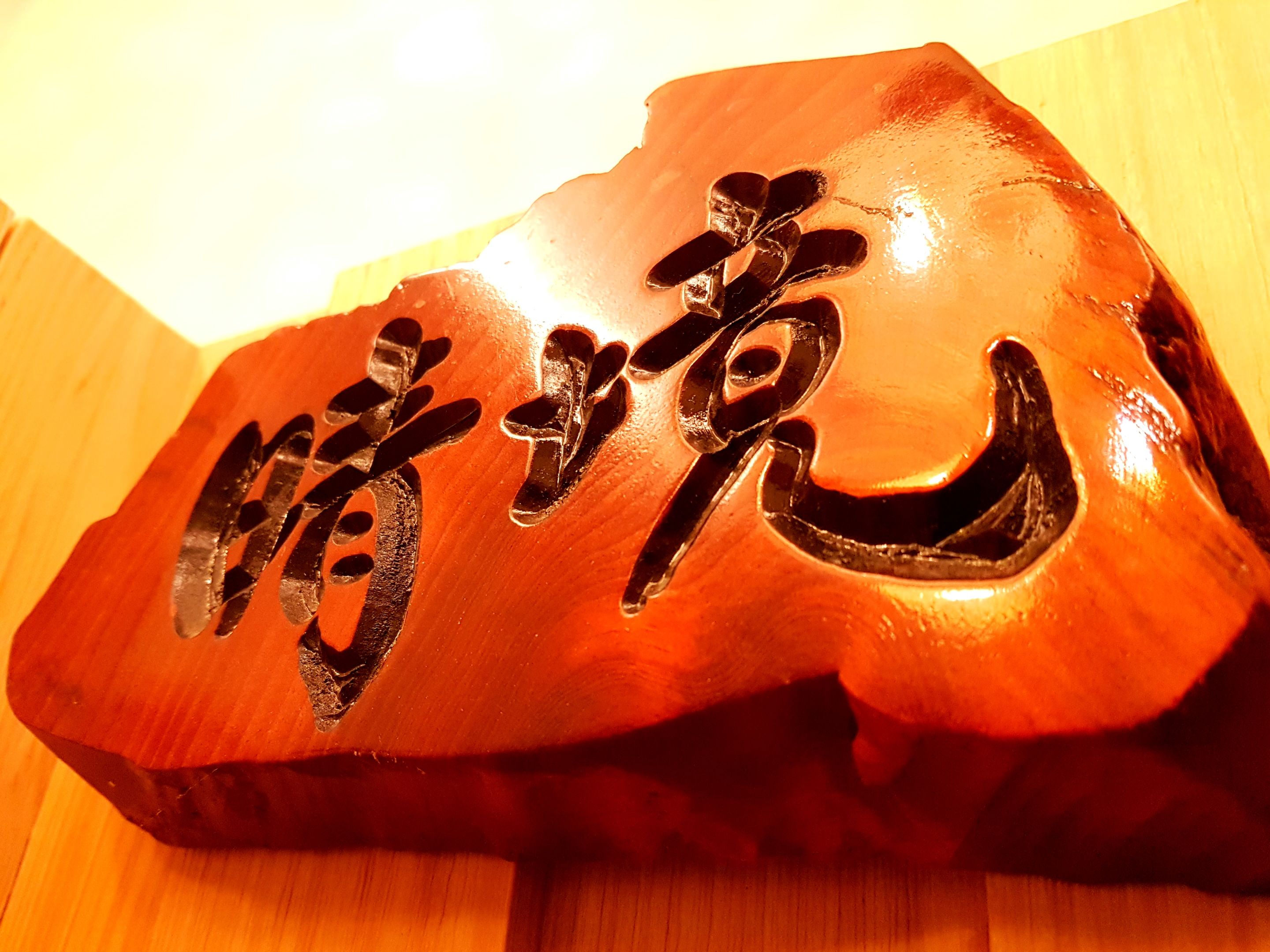 A wooden plaque with carved Chinese characters.