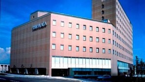 A multi-story hotel with a flat facade and a prominent sign on the side.