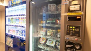Máquina expendedora con diferentes bocadillos y bebidas, y un cartel anunciando una prueba gratuita de 3 meses.