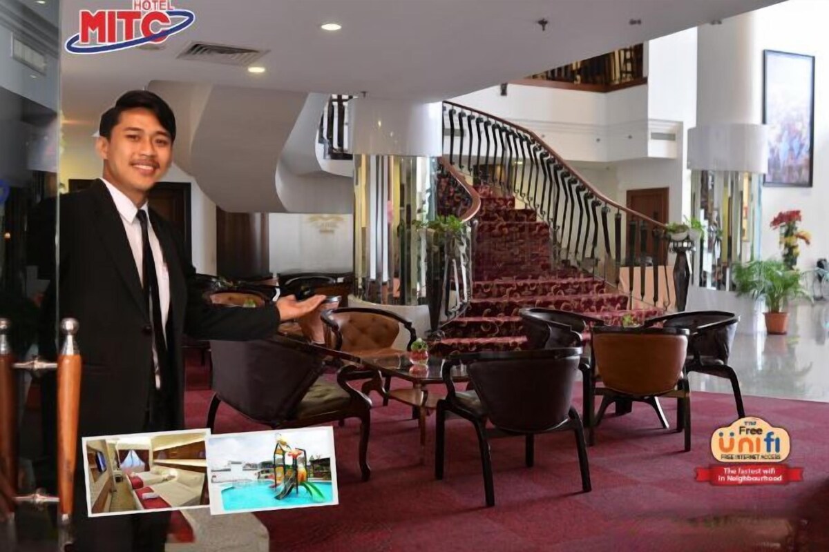 Un hall de hotel con una escalera monumental, asientos cómodos y un diseño moderno.
